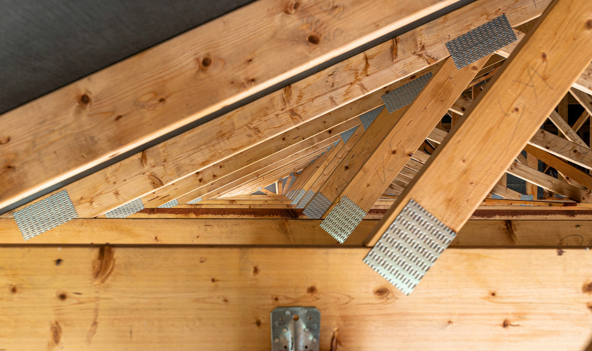 Roof trusses covered with a membrane on a detached house under construction, view from the inside, v